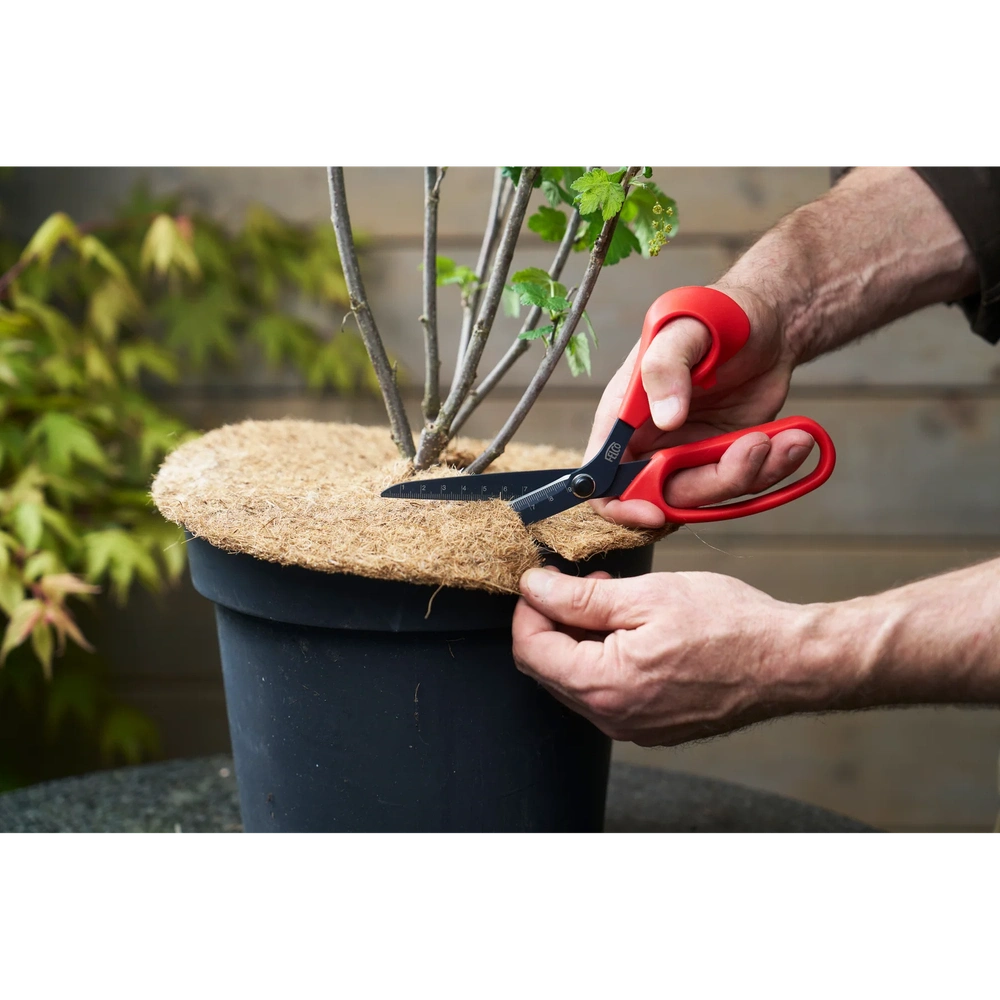 Person using Felco 455 Multi-Purpose Scissors on plant pot with a burlap cover, showcasing its precision cutting.