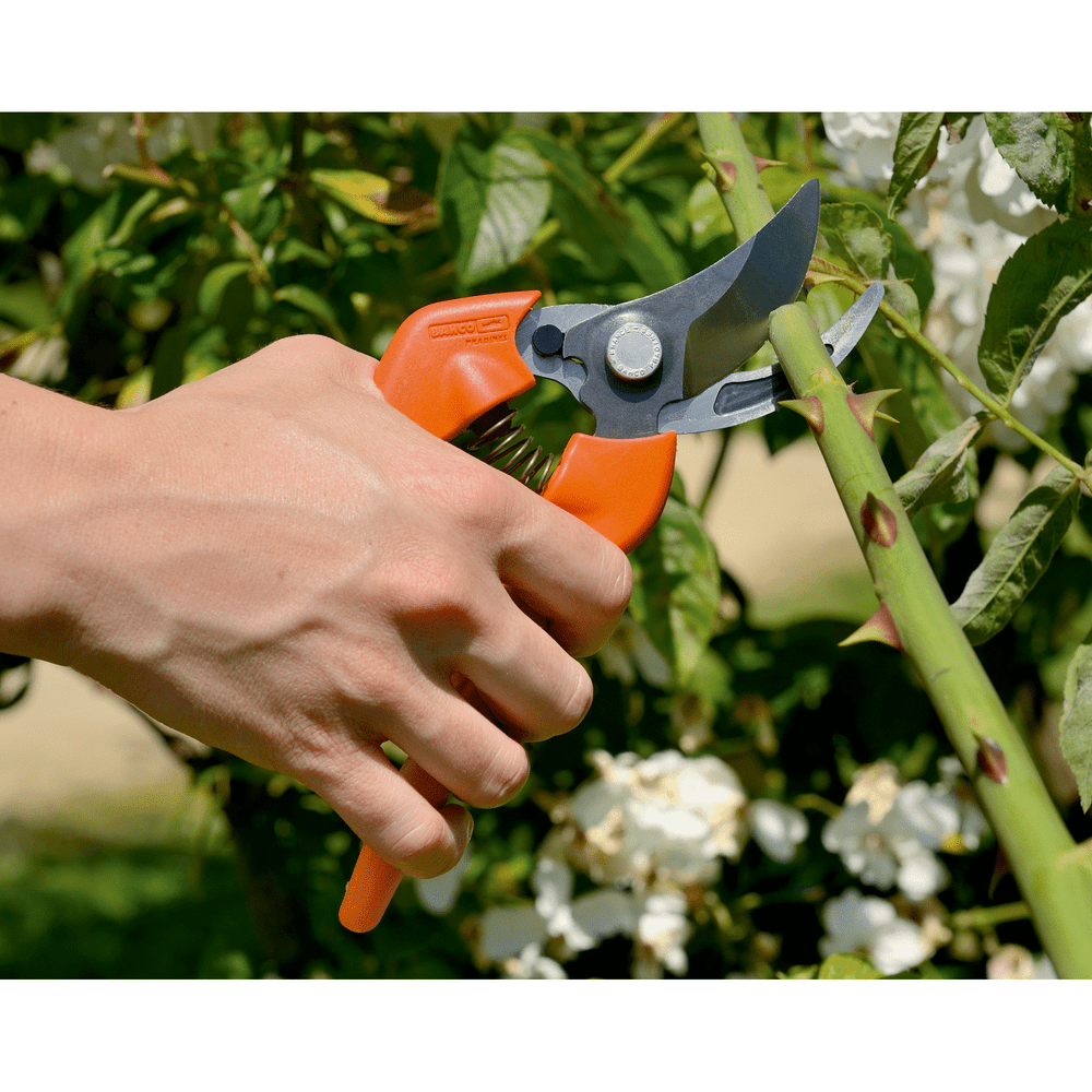Bahco Bypass Pruner with composite handle cutting branches in a garden, showcasing ergonomic design and efficiency.